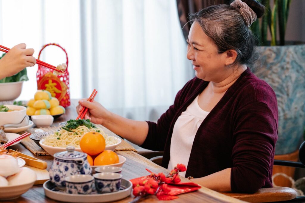 A smiling woman in her fifties at a family meal at home