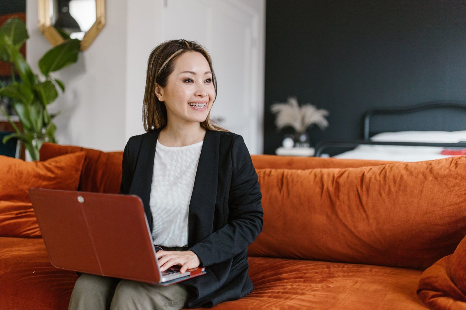 A woman in her forties smiling on a sofa at home