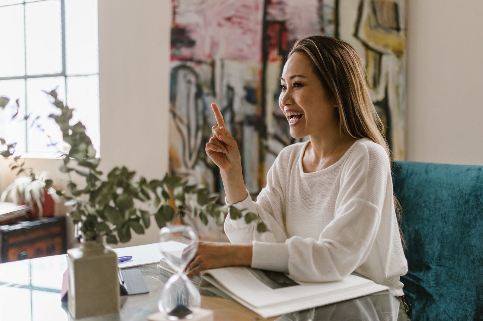 A woman in her forties smiling at her desk at home