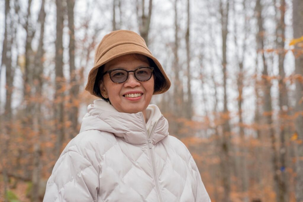 A smiling woman in her fifties in a warm coat on an autumn walk