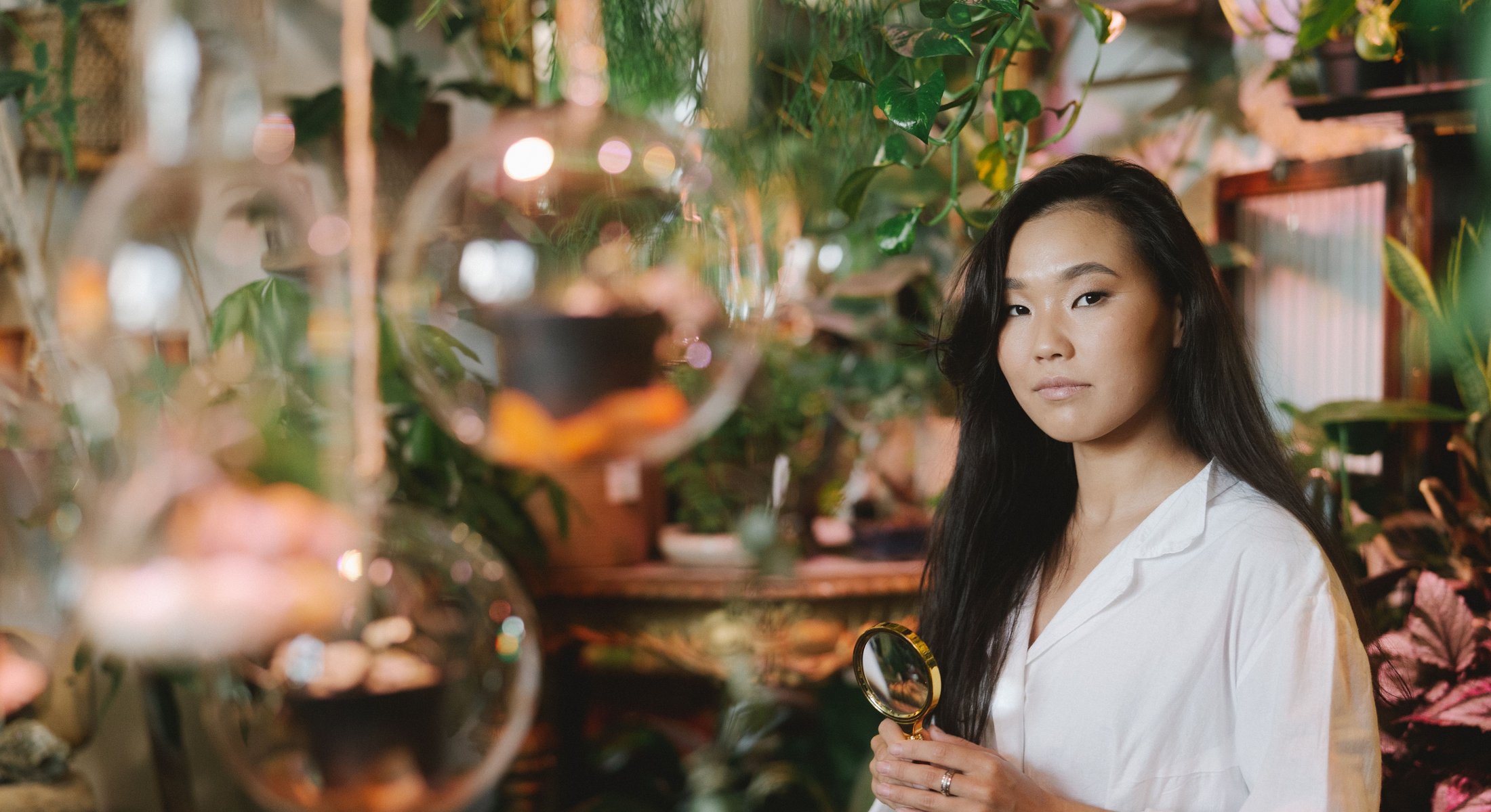 A botanist examining plant specimens in a research greenhouse