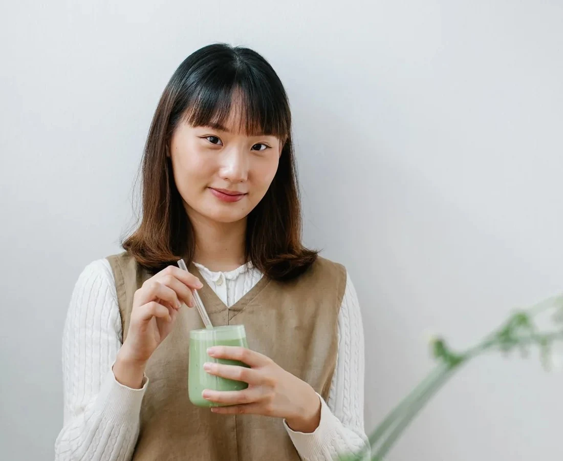 A younger woman with a green drink